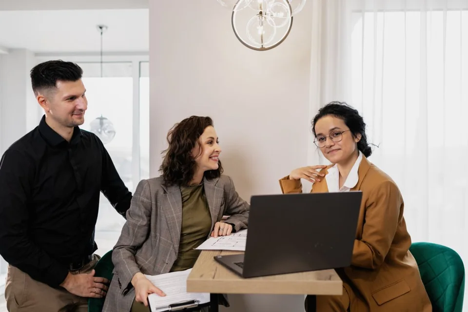 Immobilienberaterin im Beratungsgespräch mit einem Paar im Büro